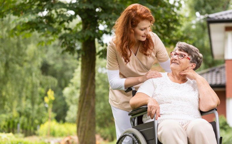female volunteer helping an elderly woman in a wheelchair
