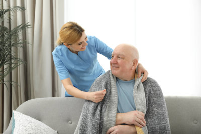 woman giving warm clothes to senior